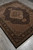 Full rug photographed diagonally on grey tile floor, whole medallion and all four borders