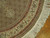Detail of border corner showing rust bands, ivory floral band and thick cream fringe against parquet