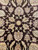 Tight detail of a small central rosette flanked by leafy palmettes outlined in crimson