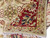Corner folded back over the pile, showing border, gold rosette medallion and ivory fringe