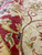 Folded border edge in crimson with gold palmettes and navy leaves beside the light field