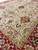 Angled view where the field of vine ovals meets the burgundy border and guard stripes