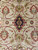 Close overhead of a small navy lozenge medallion flanked by red fan-shaped palmettes