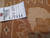Paper inventory tag numbered 5581 pinned to the honey border pile of the rug