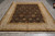 Rug lying flat on grey tile floor, seen lengthwise with cream fringe nearest the camera