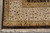 Corner detail of the ivory border with vine, vase and star flowers above brown selvedge
