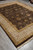 Whole rug photographed at an angle on grey tile, borders and fringe fully in view