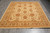 Full rug on grey plank flooring, angled view showing both end borders and guard stripes