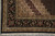 Corner photographed from above with palmette border, guard stripes and fringed end on tile