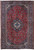 Full view of red Persian Ardakan rug with navy lobed central medallion and navy floral border