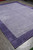 Angled view of the rug on a warehouse floor showing border width on two sides
