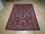 The rug laid flat on a concrete floor, photographed lengthwise from one end with fringe in front