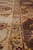 Angled close view of the beige border with pink guard stripe beside the brown field