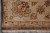 Corner of the beige border with palmette, guard stripes, dark selvedge and ivory fringe