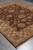 Whole rug viewed diagonally on a grey floor, brown field inside the beige border