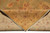 Corner of the pile folded back to show the reverse, pattern legible through the knots