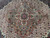 Close-up of the central medallion, rose-brown petals around a teal rosette on ivory lattice