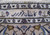 Detail of the border cartouche with a dark woven inscription between ivory and blue guard stripes