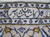 Close-up of the woven signature cartouche lettered in dark navy on ivory within the end border