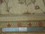 Back of the rug with fringe and a ruler held against the knotted border for scale