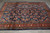 Angled view across the rug from one end, border foreshortened, floral field filling the frame