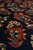 Low raking shot across the pile showing a cream and red bouquet motif in relief