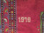 Close view of the date 1970 knotted in ivory wool on the red field