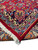 Folded corner showing ivory cotton fringe, red selvage and the knotted reverse side