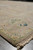 Angled corner view showing tight selvage, ivory fringe and the warm taupe field tone