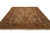 Angled front view of the hand-knotted wool rug showing olive green and rust floral border