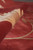Rolled edge detail revealing dense plush pile depth and burgundy red color saturation of the weave