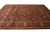 9x12 Indian Oriental rug seen at an angle, rust field with olive green vine scrolls