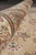 Rolled edge of the wool and silk rug revealing plush pile depth and border drawing