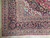Corner detail showing multi-band border, grey blue guard stripes and clean ivory wool fringe