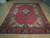 Angled view of large red and ivory hand-knotted wool Sarough rug in 10x14 size