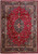 Deep red Persian Mashad rug with navy floral medallion, ivory borders and corner spandrels, full view