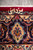 Vertical close-up of the woven weaver signature above an apricot cartouche in the navy border
