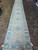 3'1" x 19'11" runner photographed down its length on travertine tile, showing repeating medallions
