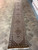 Extra long wool and silk runner laid on tile floor, ivory field and brown border