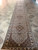 17 foot long hallway runner stretched across stone tile, ivory ground and repeating medallions