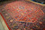 Angled view of large 10x13 hand-knotted wool Persian rug showing pile sheen and floral drawing