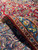 Folded corner revealing 3/8 inch wool pile, tight knotting and cotton foundation of this handmade rug