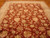 9x12 hand-knotted Indian wool rug on parquet floor with rust field and ivory border