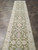 Angled view of the narrow wool runner stretching down a tiled corridor toward the fringe