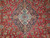 Close-up of the ivory and teal lobed medallion framed by midnight navy on a tomato red field