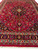 Angled view showing burgundy field, ivory guard borders and indigo paisley main border band