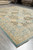 Corner perspective highlighting the cream outer border, olive vines and low even wool pile