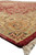 Side edge detail with hand-finished red selvage, ivory fringe and finely drawn border flowers