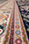 Guard stripes in olive, pink and mauve with small blue rosettes shown in close-up