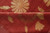 Folded edge showing even low pile depth, golden seed head and leaf vines on red